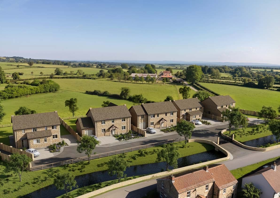 Aerial view of seven stone houses beside a winding road and beck, with fields beyond