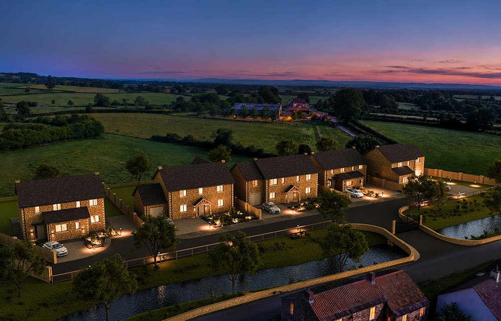 The development at dusk, with lit windows and a pink and blue sky