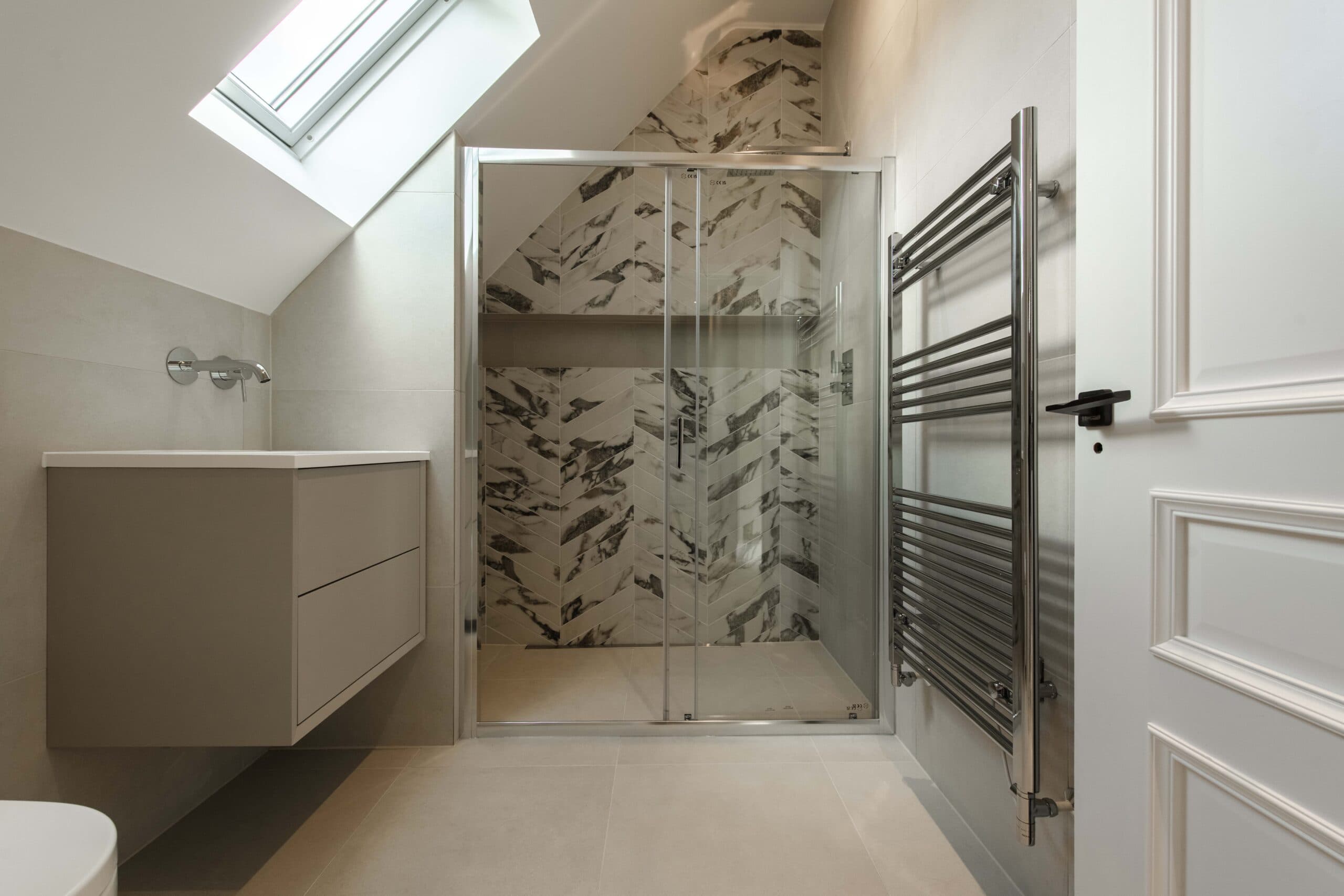 Shower room with a walk-in shower, patterned tiles and a heated towel rail